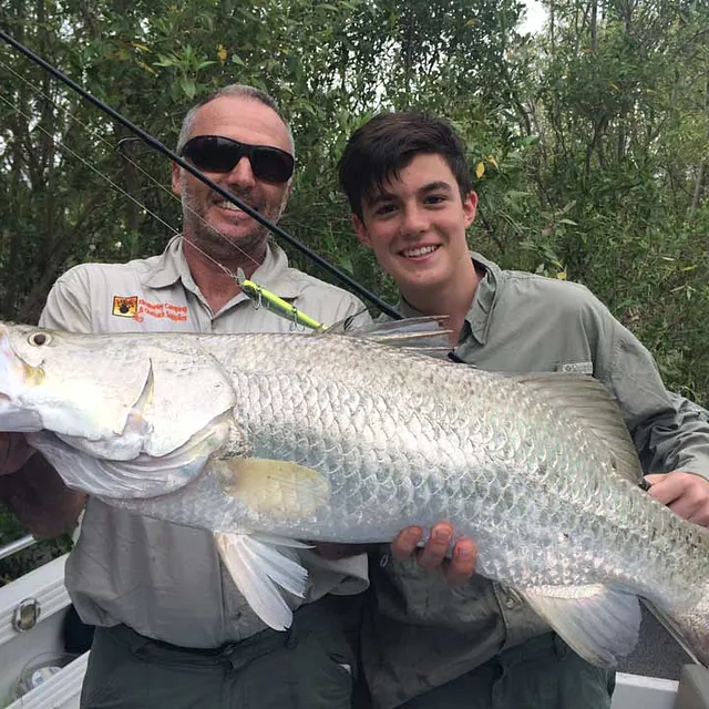 A father and son with a large fish. 